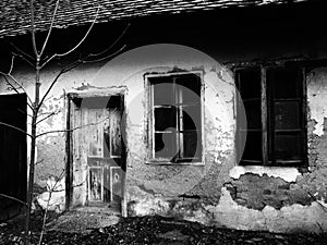 Old house with windows and a door. Collapsing rural house. The concept of urbanization and oblivion of the motherland. Abandoned