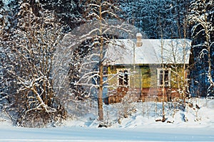 Old house in the winter forest