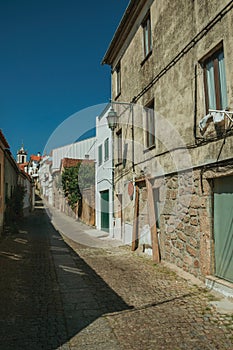 Old house with worn plaster wall and narrow alley