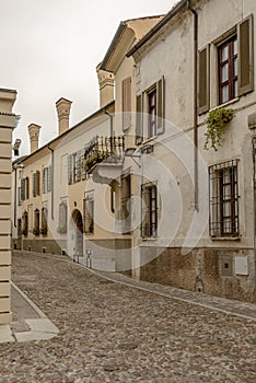 Old houses on cobbled street in city center, Mantua, Italy