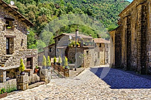 Old houses made of stone with flowers and decorative objects in the pretty village of Beget, Girona, Spain.