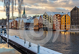 Old houses and magazines by Nidelva river in Trondheim, Nidarosdomen Cathedral in back