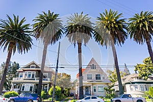 Old houses and palm trees on a street in downtown San Jose, California photo