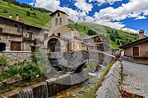 Old houses, parish church and old bridge in Chianale, Italy