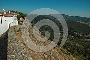 Old houses and stone breastwork with mountainous landscape