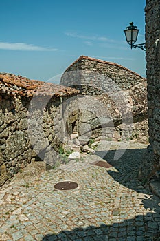 Old houses and stone wall with big rock in Monsanto