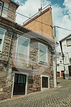 Old houses with stone wall in a deserted alley