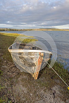 Old hull of motor boat on river bank