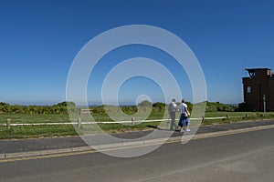 Elderly couple walking hand in hand near the sea.