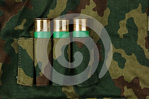 Old hunting cartridges and bandoleer on camouflage