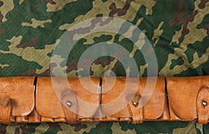 Old hunting cartridges and bandoleer on camouflage