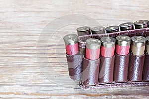 Old hunting cartridges in bandoleer on a wooden table