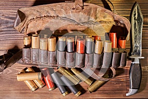 Old hunting cartridges and bandoleer on a wooden table