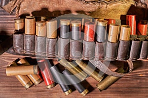 Old hunting cartridges and bandoleer on a wooden table