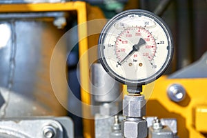 Old hydraulic pressure gauge on yellow equipment