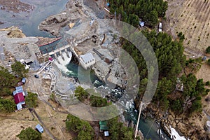 Old hydroelectric power station on Chemal river in Altai on a summer day aerial view from above by drones