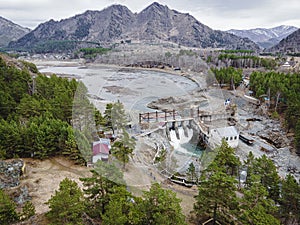 Old hydroelectric power station on Chemal river in Altai on a summer day aerial view from above by drones