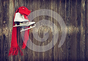 Old ice skates hanging on rustic wooden wall