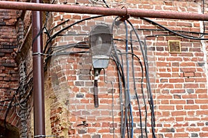 Old idle lantern and electrical wires on the wall.