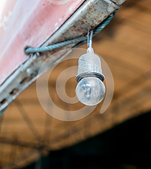 Old Incandescent light bulb hanging on black electric wire