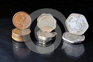 An old Indian one two and three paisa coins isolated on a black background.
