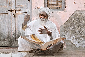 Old indian sadhu reading scriptures. photo