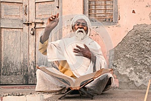 Old indian sadhu speak up sacred scriptures. photo