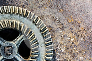 Old industrial gear wheel against rusty metal background