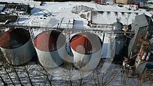 Old industrial grain silos grain storage tanks from drone in winter, aerial