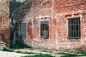 Old industrial metallic grid window with mullion and muntin on ruined factory building