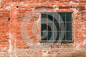 Old industrial metallic grid window with mullion and muntin on ruined factory building