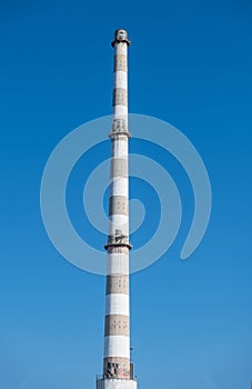 Old industrial plant chimney, sunny day, vertical photo