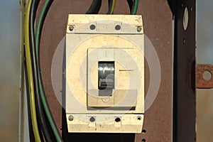 An old industrial plastic electric switch is white in an iron box with wires