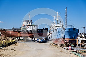 Old industrial ship boat in dry dock for repair, harbor in Greece, sunny day