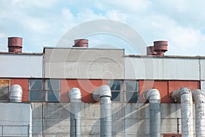 Old industry plant with pipes and tubes. Outside view of manufacturing complex under blue cloud sky. Concrete walls, metal frames