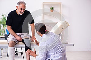 Old injured man visiting young male doctor traumatologist