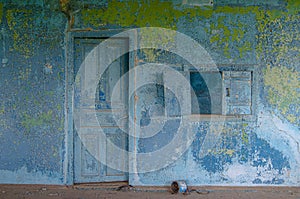 The inner wall of the room is blue with a window.