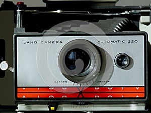 old instant camera frontal close-up view with red and silver face plate