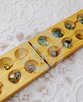 Old intelligence games, wooden mancala game, a person playing mancala