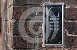 Old intercom on a red brick wall