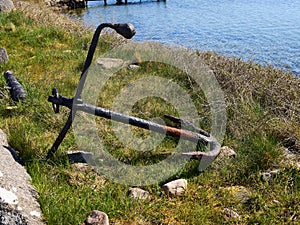 Old iron anchor on shore by the ocean