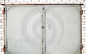 An old iron door closed with brick wall