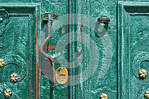 Old iron door, forged and painted in green color with golden flowers for background, vintage style, retro elements