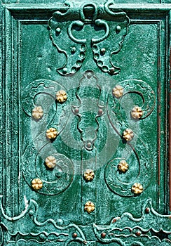 Old iron door, forged and painted in green color with golden flowers for background, vintage style, retro elements