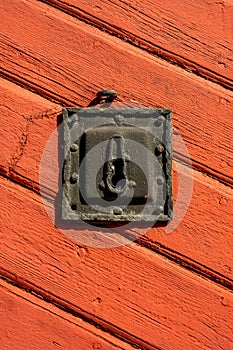 Old iron door lock on a red wooden door