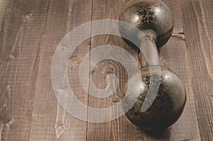 Old iron dumbbell/old iron dumbbell on dark wooden background wi