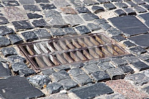 The old iron grate of the drainage system hatch.