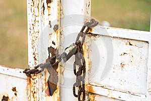 Old iron lock hangs on a rusty gate closed