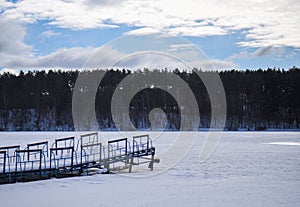 Old iron pier on a frozen river in winter