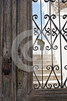 Old iron rusty door handle in the shape of a hand. Brown wooden door of a house in the Greek city of Tira, on the island of